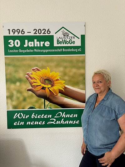 Christina Blödgen vor einem Poster "30 Jahre BeWoGe"